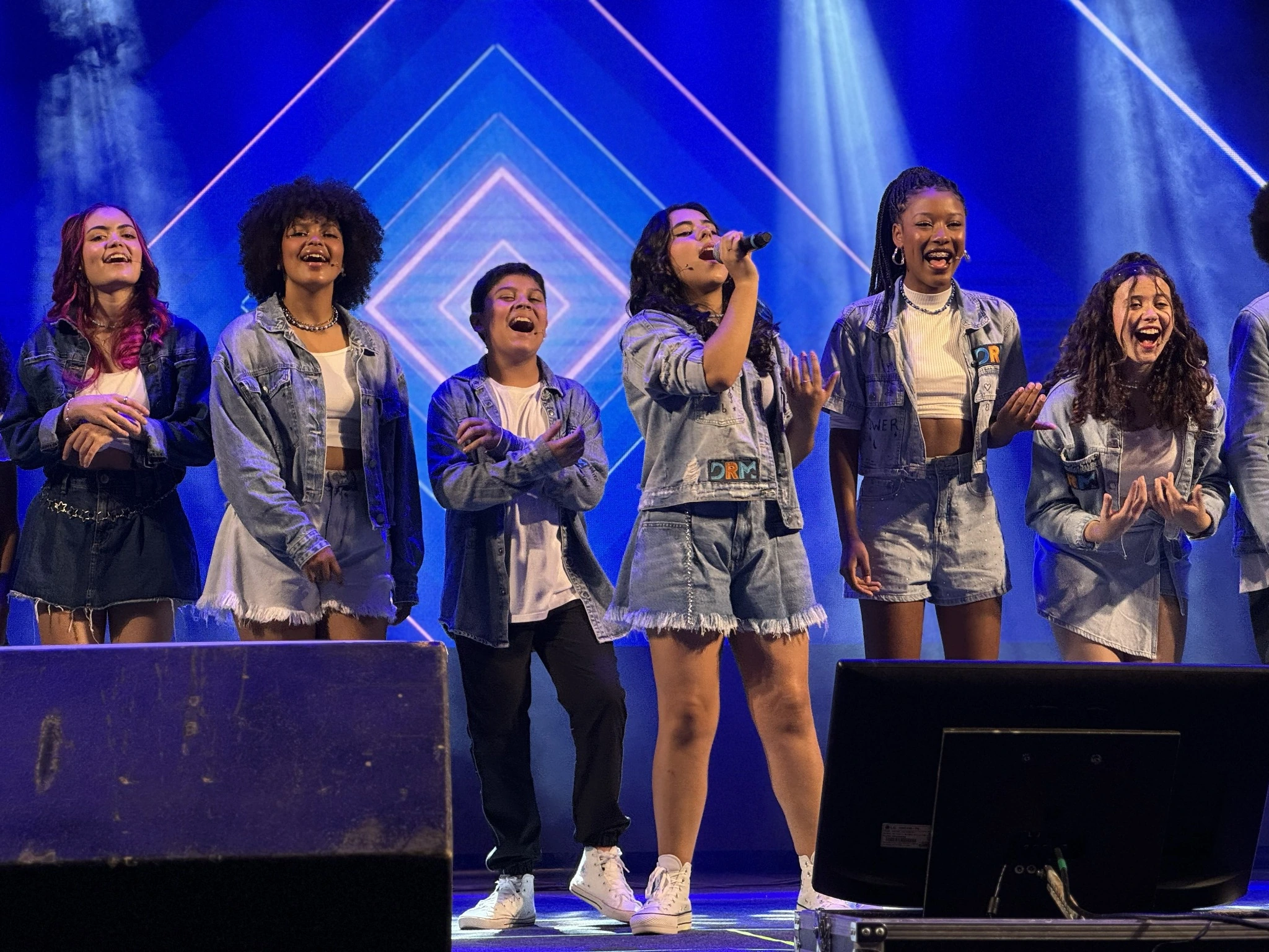 Integrantes do DRM cantando juntos no palco