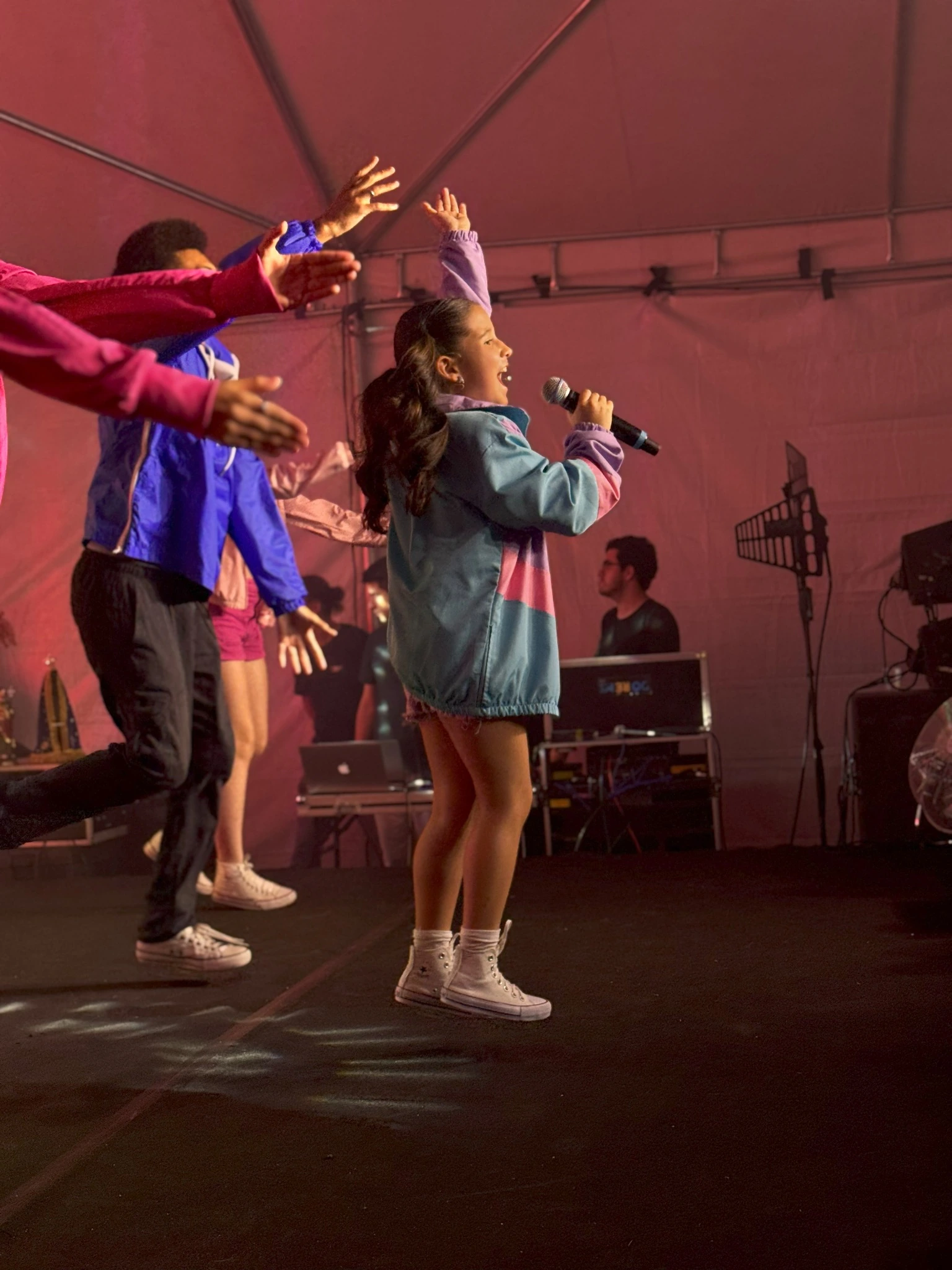 Cantores DRM se apresentando em palco ao ar livre