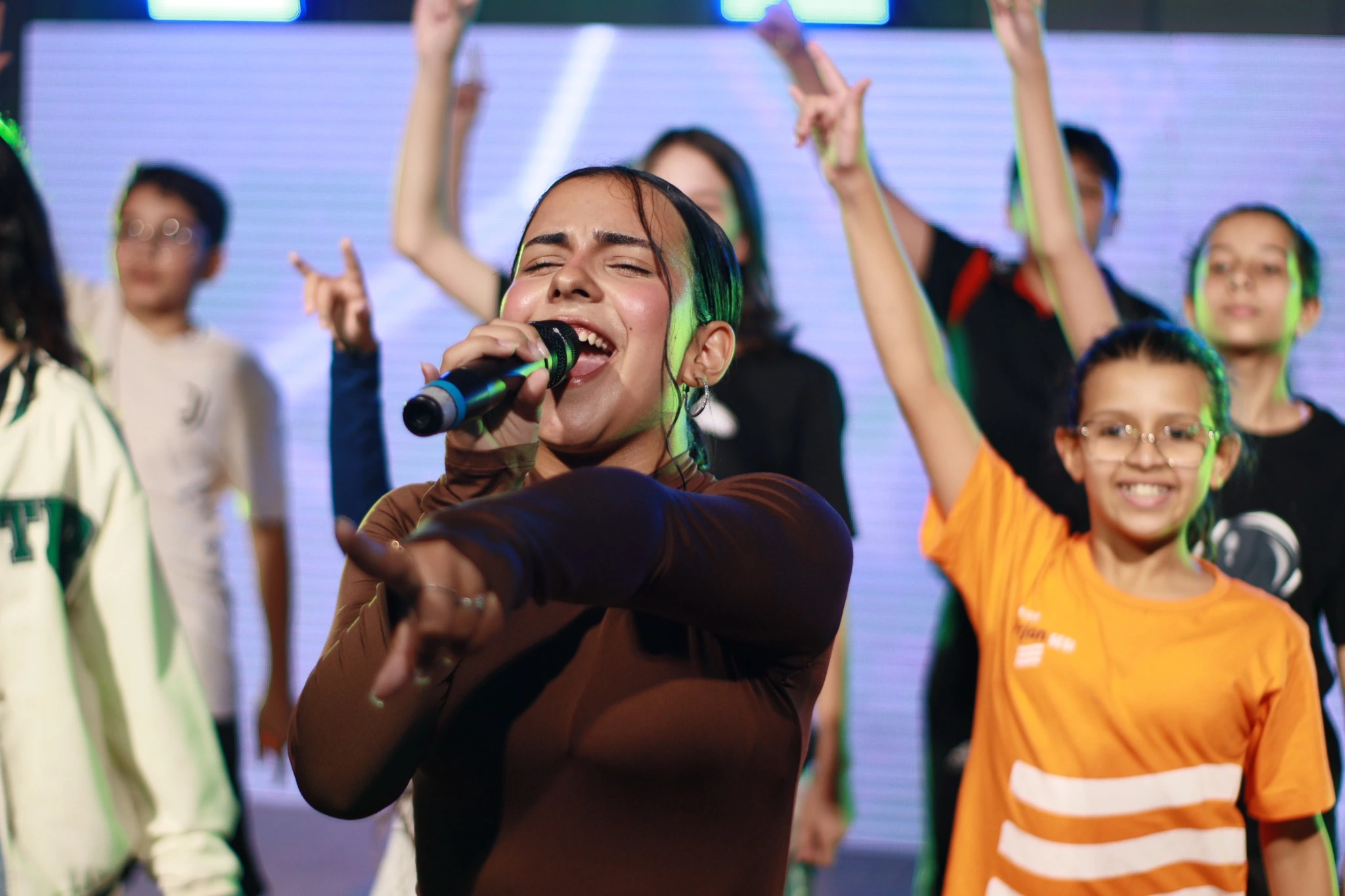 Cantora e integrantes do DRM em apresentação vibrante